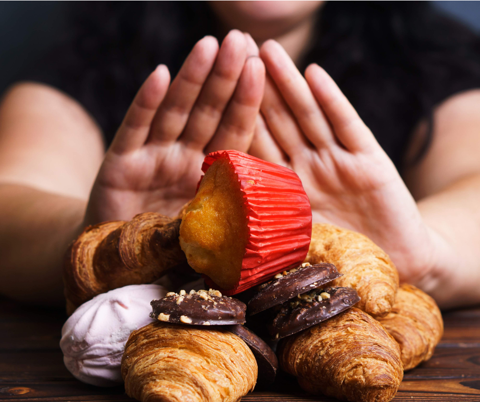 Woman pushing away a pile of sweets and treats